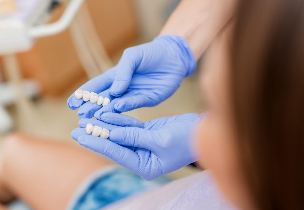 64ad7cffe377ac2bb0a8ad9d gloved hands holding Dental Crowns in Englewood