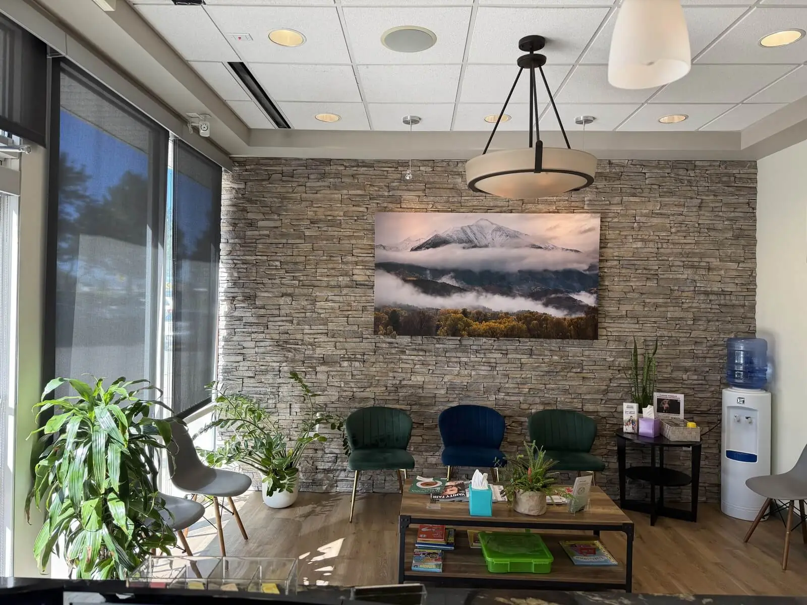 Sopris Smiles waiting room in Englewood with stone wall and mountain artwork